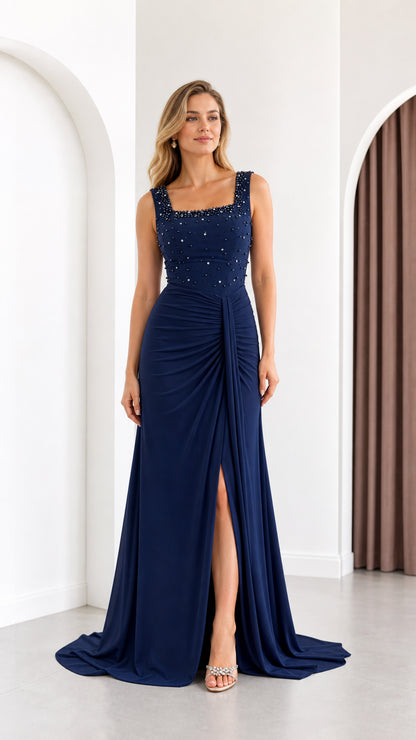 Full front view of a woman wearing a navy blue beaded square neck evening gown with front slit