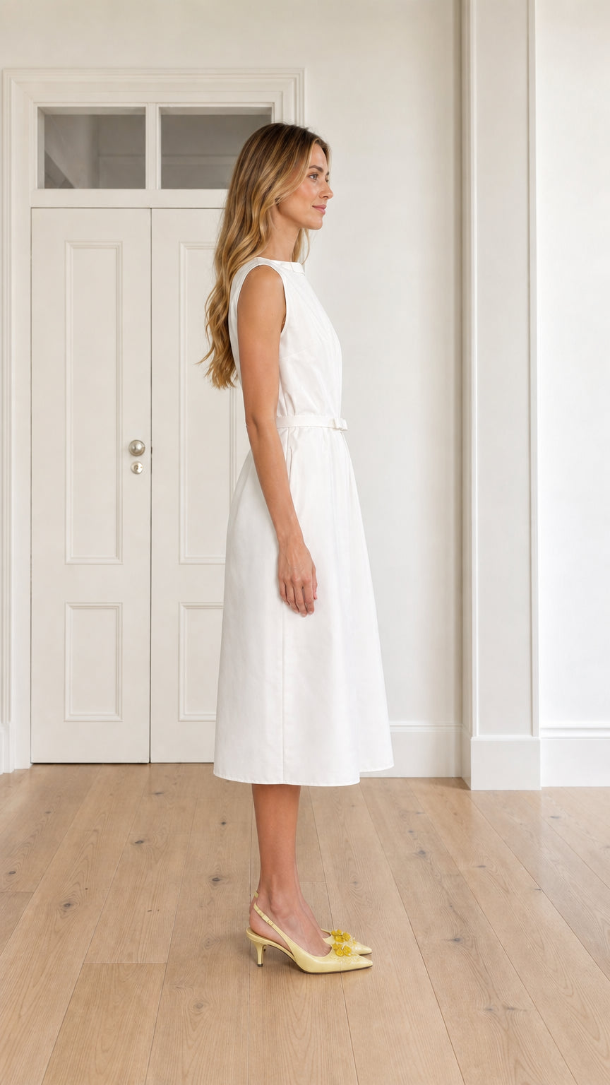 Side profile of woman wearing white sleeveless pleated A-line midi dress