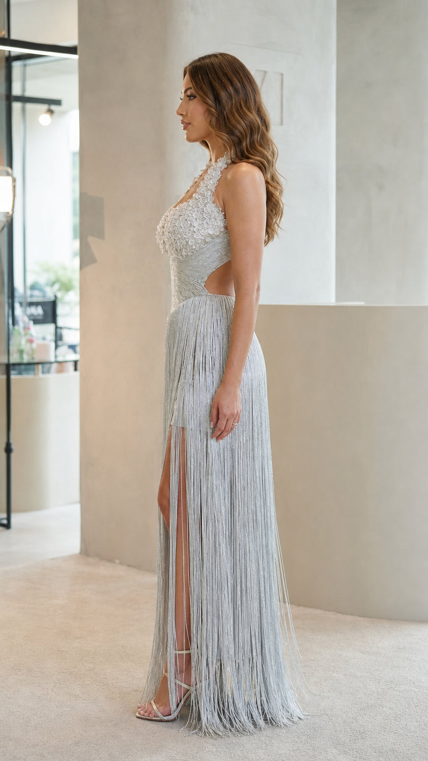 Side profile view showing side cutout and high slit of silver fringe evening gown