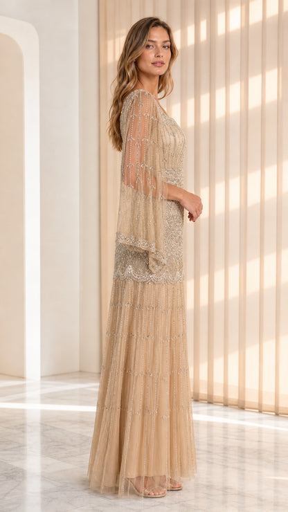Side angle of model wearing champagne gold beaded evening dress with cape sleeves