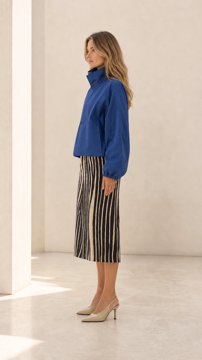 Side profile view of woman wearing royal blue cropped stand collar blouson jacket