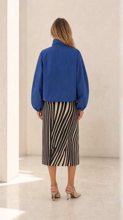 Back view of woman wearing royal blue cropped jacket with gathered sleeves