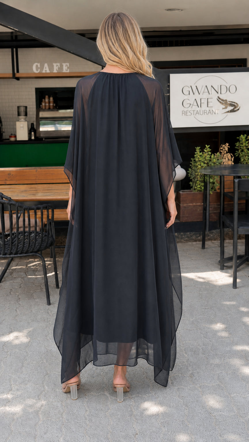 Model wearing black chiffon kaftan maxi dress back view