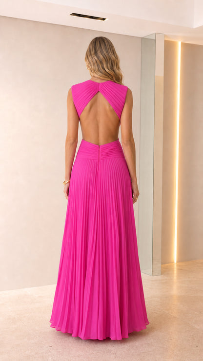 Back view of woman showing open back detail of hot pink pleated maxi dress