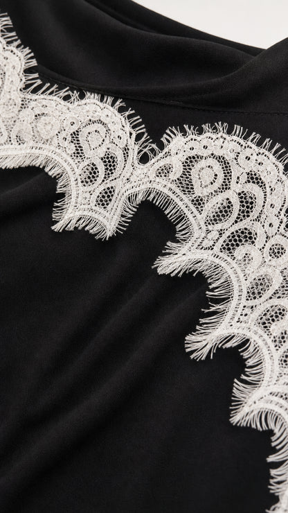 Close-up of white lace trim on black fabric