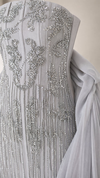 Close-up detail of silver sequin and beaded embroidery on dusty blue gown