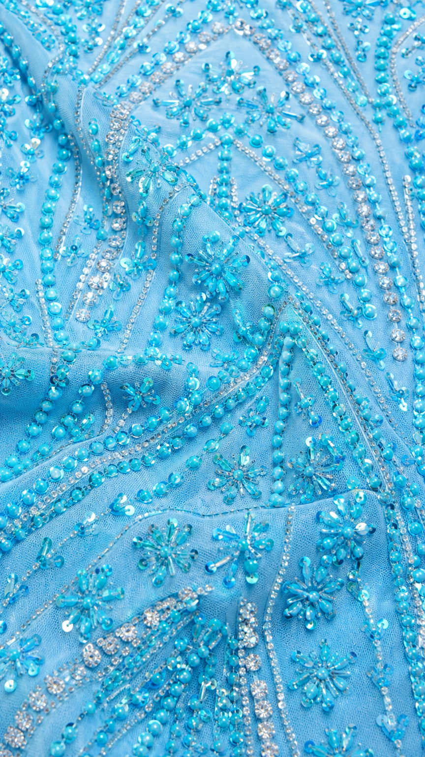 Close-up detail of intricate blue floral beading and sequin embellishments on mesh