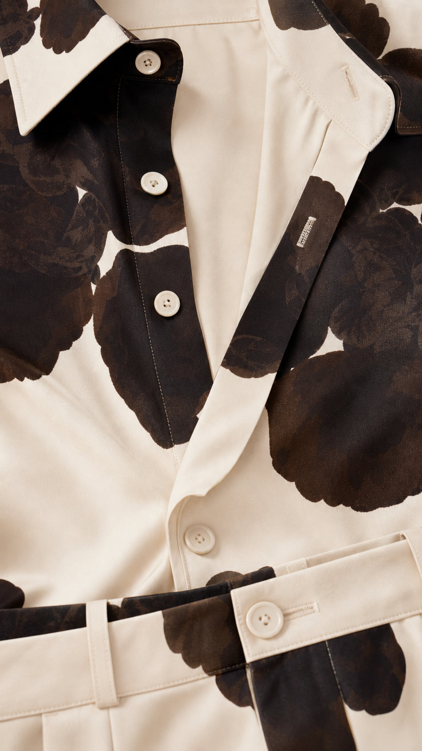 Close-up detail of button placket, collar, and waistband on cream floral set