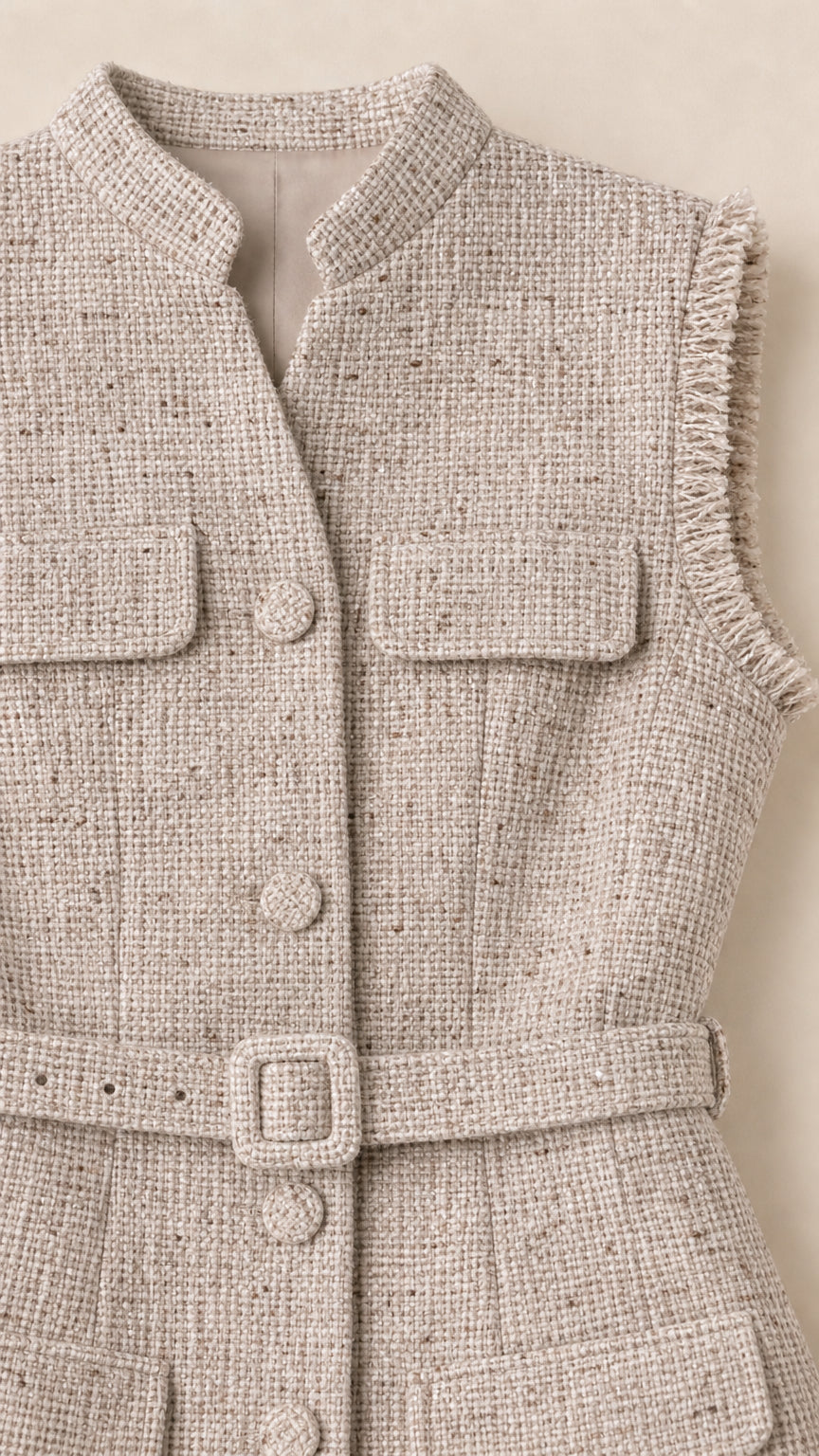 Close-up of the oatmeal textured fabric, front buttons, flap pockets, and belt buckle