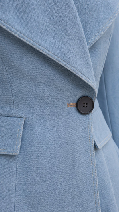 Close-up detail of sky blue jacket fabric texture, lapel, and single button closure
