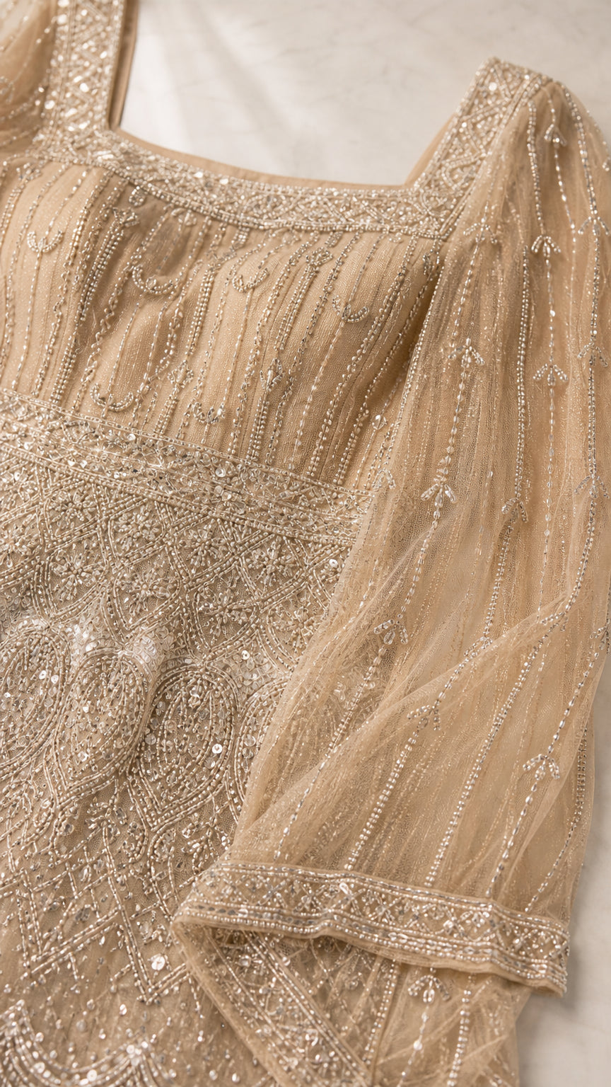 Close-up detail of intricate beadwork, sequins, and square neckline on tulle mesh fabric