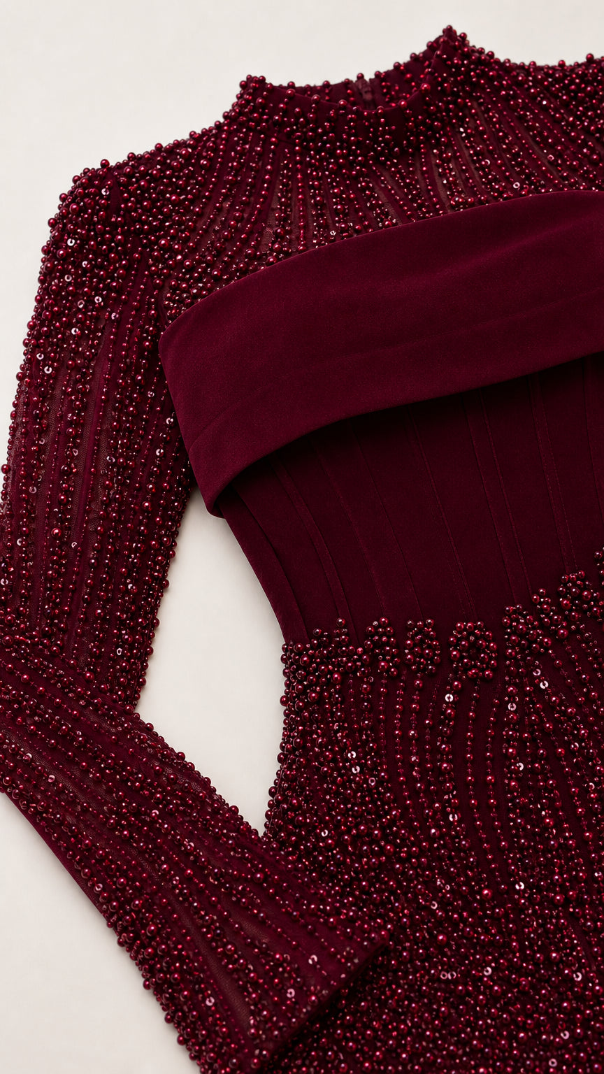 Close-up detail of burgundy beadwork and structured bodice overlay