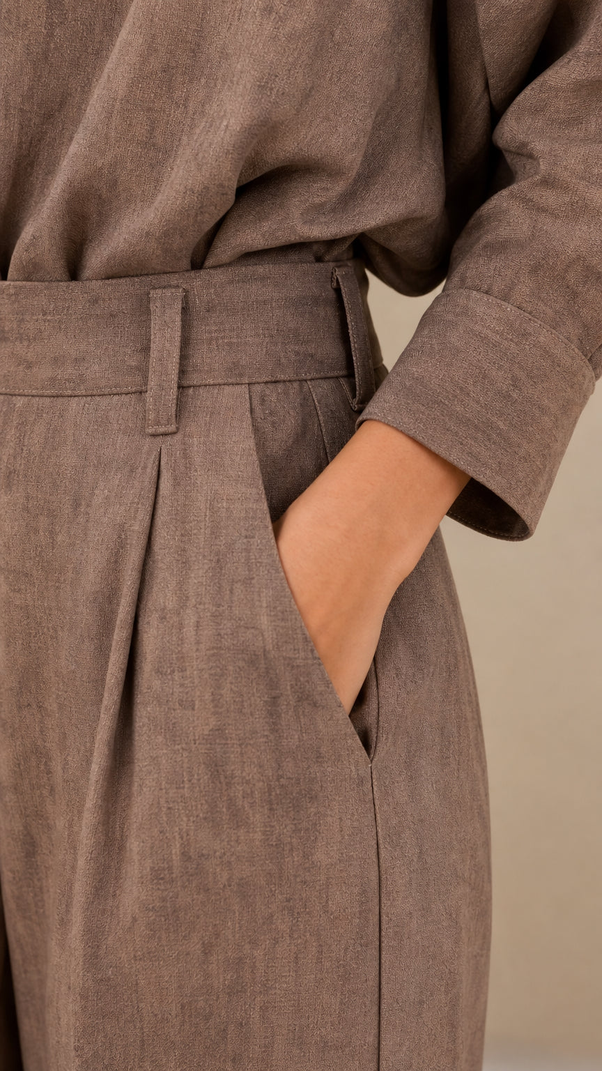 Close-up detail of waistband, pleats, pocket, and cuff on taupe matching set