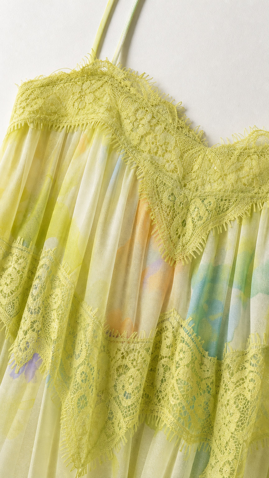 Close-up detail of delicate eyelash lace trim on pleated floral fabric