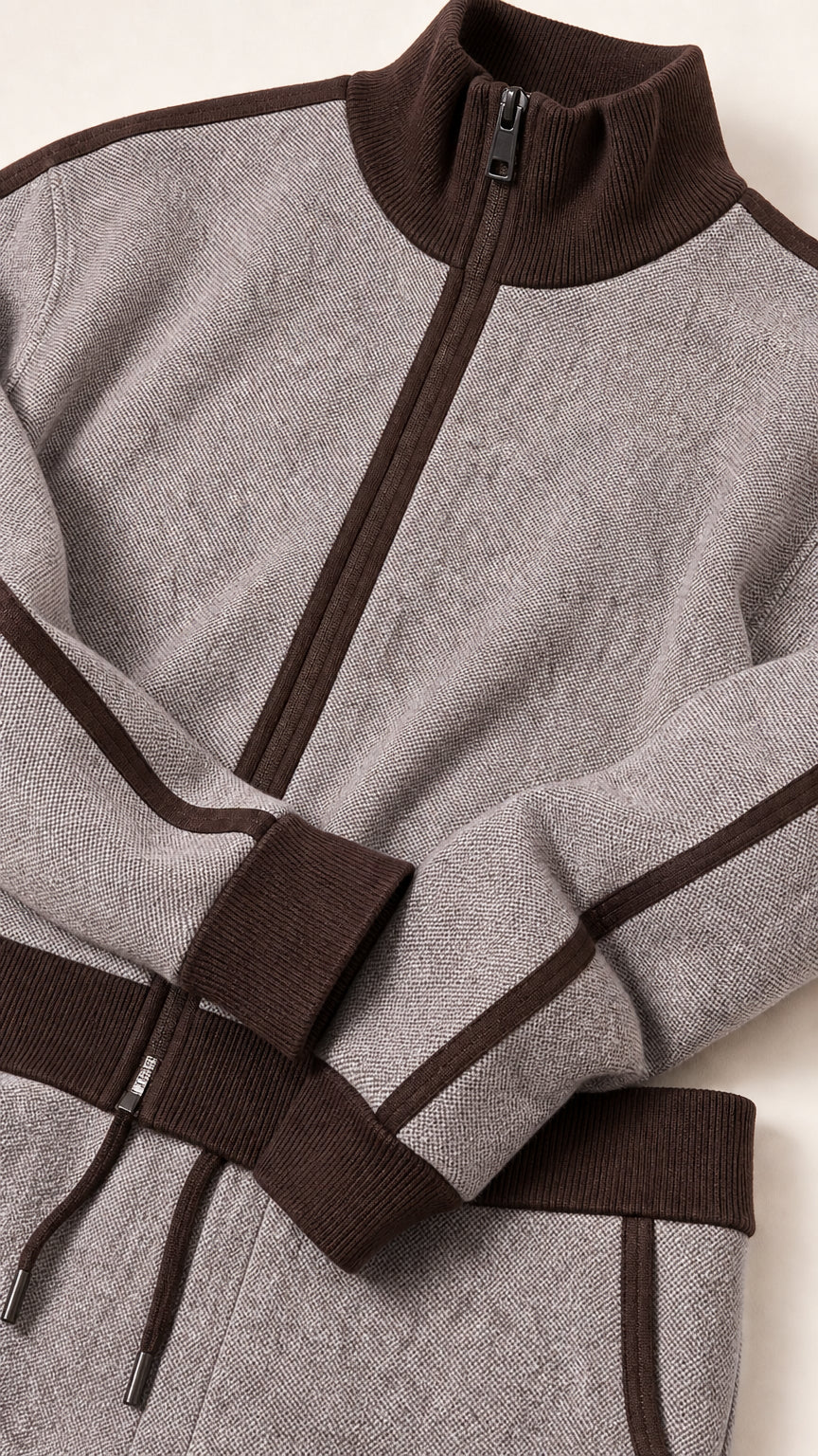 Close-up detail of textured knit fabric, zipper, and ribbed contrast trim