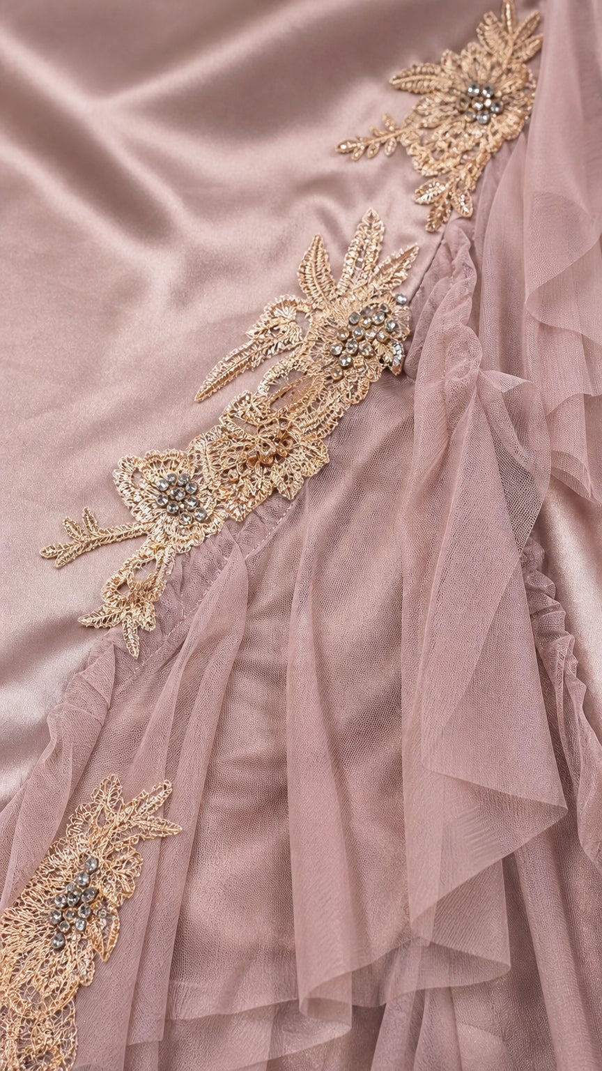 Close-up detail of golden floral lace embroidery and sheer tulle ruffles