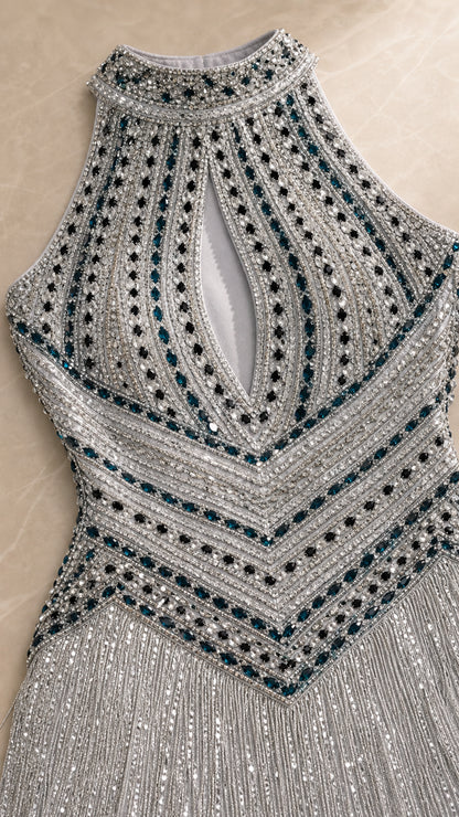Close-up of silver geometric beadwork and fringe detailing