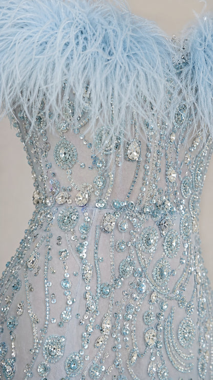 Close-up detail of light blue feather neckline and intricate sequin beading