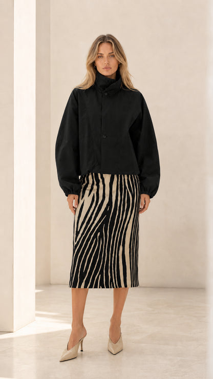 Front view of woman wearing black cropped high neck blouson jacket