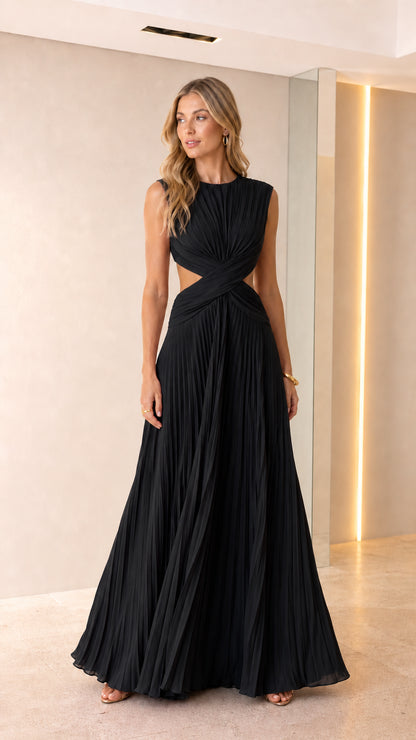 Front view of woman wearing black sleeveless pleated cutout maxi gown