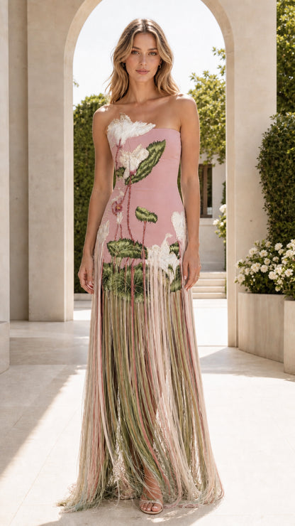 Front view of blush pink strapless maxi dress with botanical embroidery and floor-length fringe