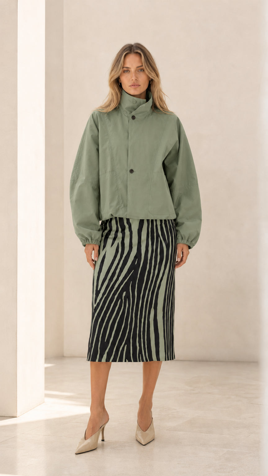 Front view of woman wearing sage green cropped high neck jacket