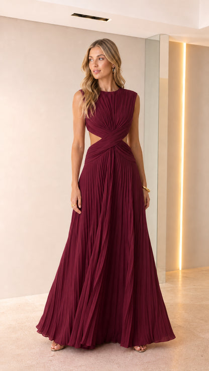 Front view of woman wearing burgundy wine sleeveless pleated cutout maxi gown
