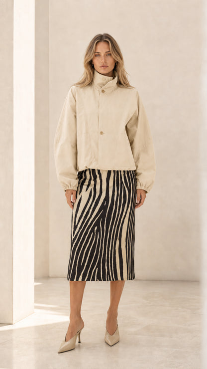 Front view of woman wearing cream off-white cropped high neck jacket